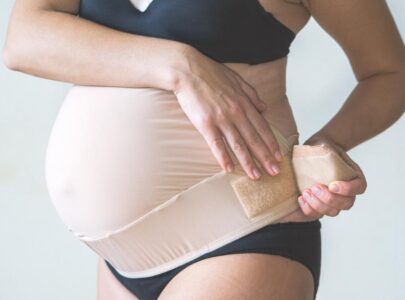 Close up of pregnant woman wearing supporting bandage